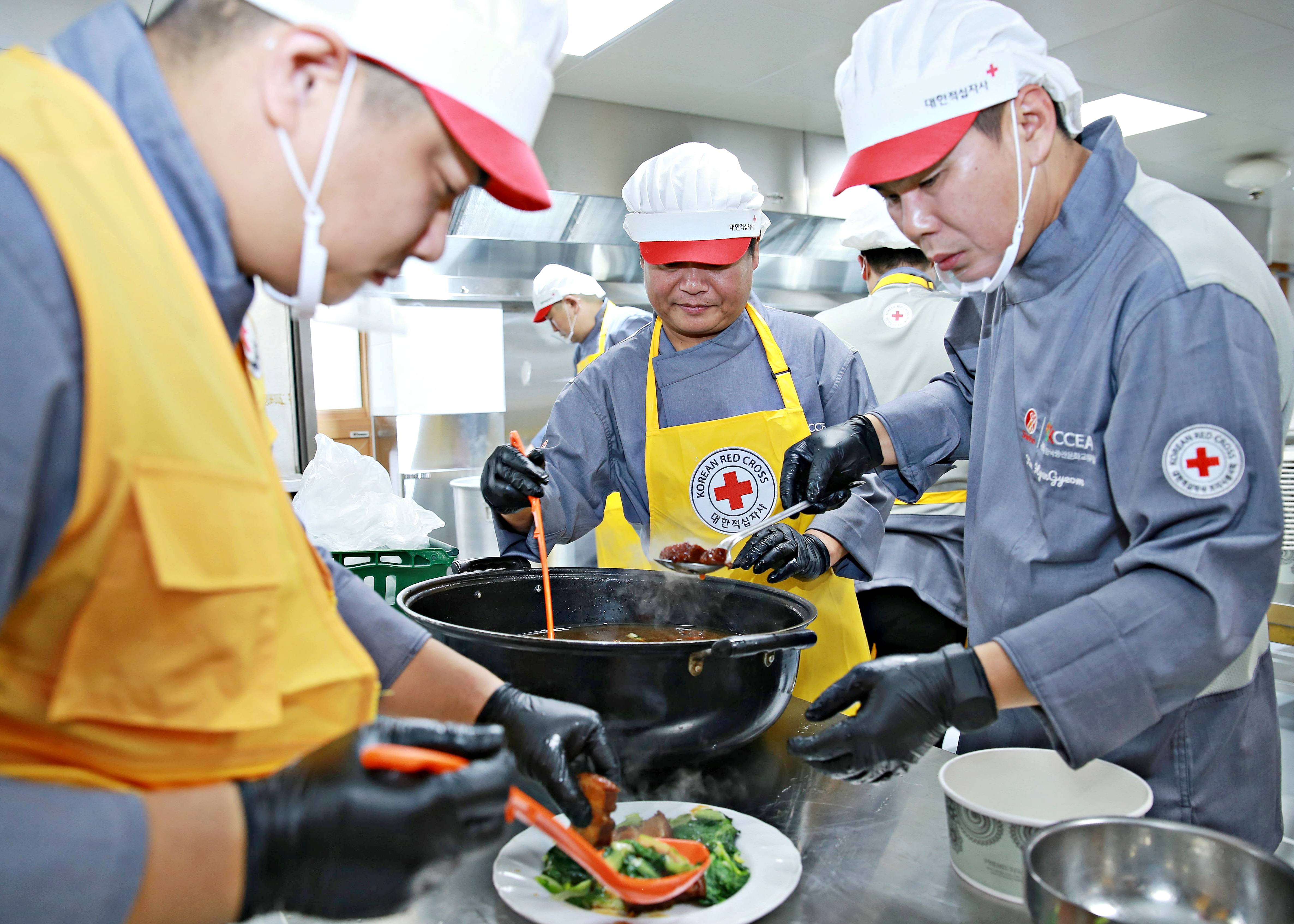 대한적십자사 서울지사 조리사봉사회원들이 취약계층에게 전해질 동파육을 담고 있다. 사진 제공 = 대한적십자사 서울지사.