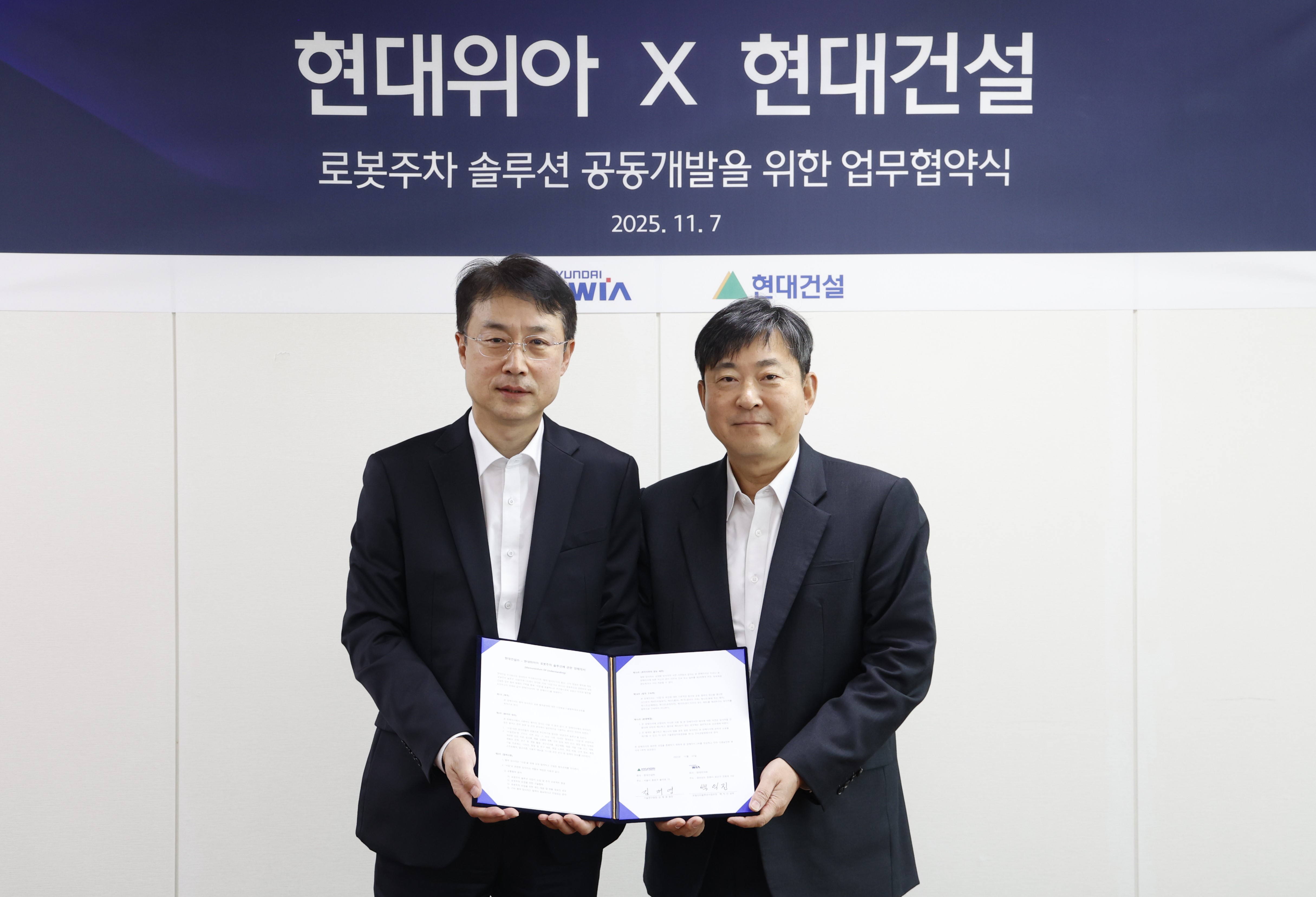 김재영(오른쪽) 현대건설 기술연구원장과 백익진 현대위아 모빌리티솔루션사업부 상무가 7일 경기도 의왕시 현대위아 의왕연구소에서 열린 ‘로봇 친화형 주차솔루션 공동개발을 위한 업무협약식’에서 기념 사진을 찍고 있다. 사진=현대건설