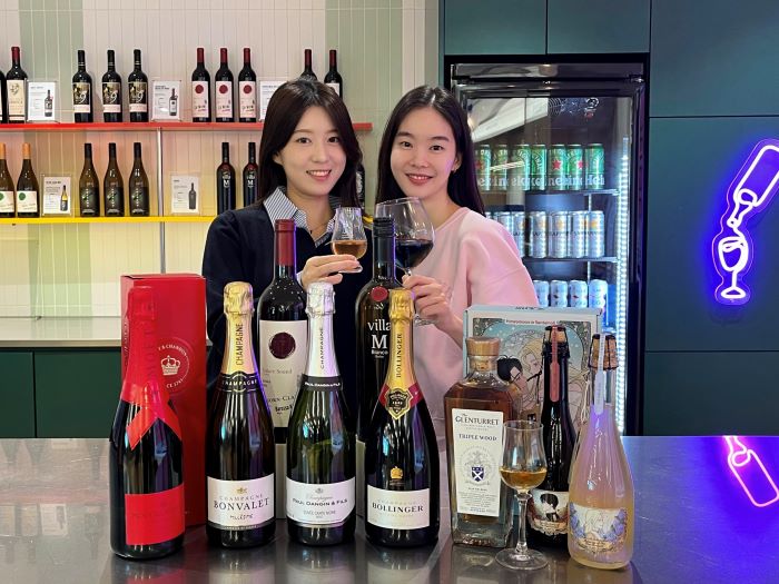 GS25에서 모델이 ‘2025 와와페’ 주류 상품을 선보이고 있다. 사진=GS리테일