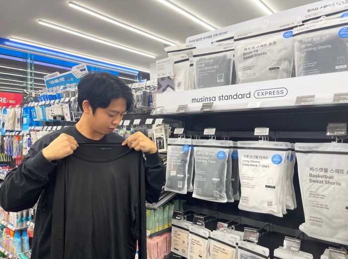 고객이 GS25에서 무신사 스탠다드의 힛탠다드 이너웨어 상품을 살펴보고 있다. 사진=GS리테일