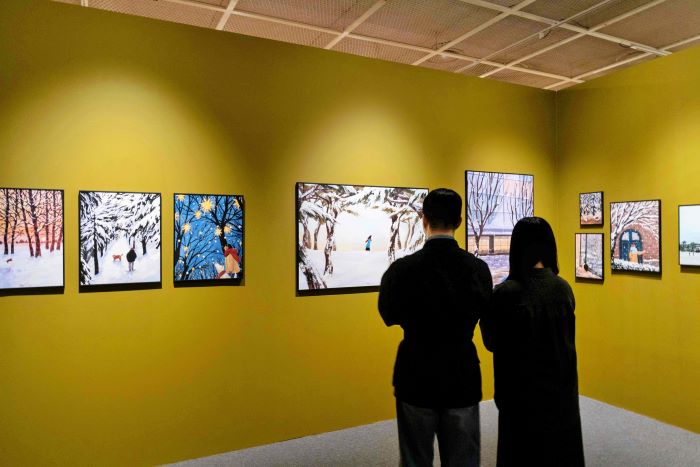 잠실점 아트홀에서 진행하는 ‘겨울, 그 따뜻한 순간들’ 전시를 관람하고 있는 고객들의 모습. 사진=롯데백화점