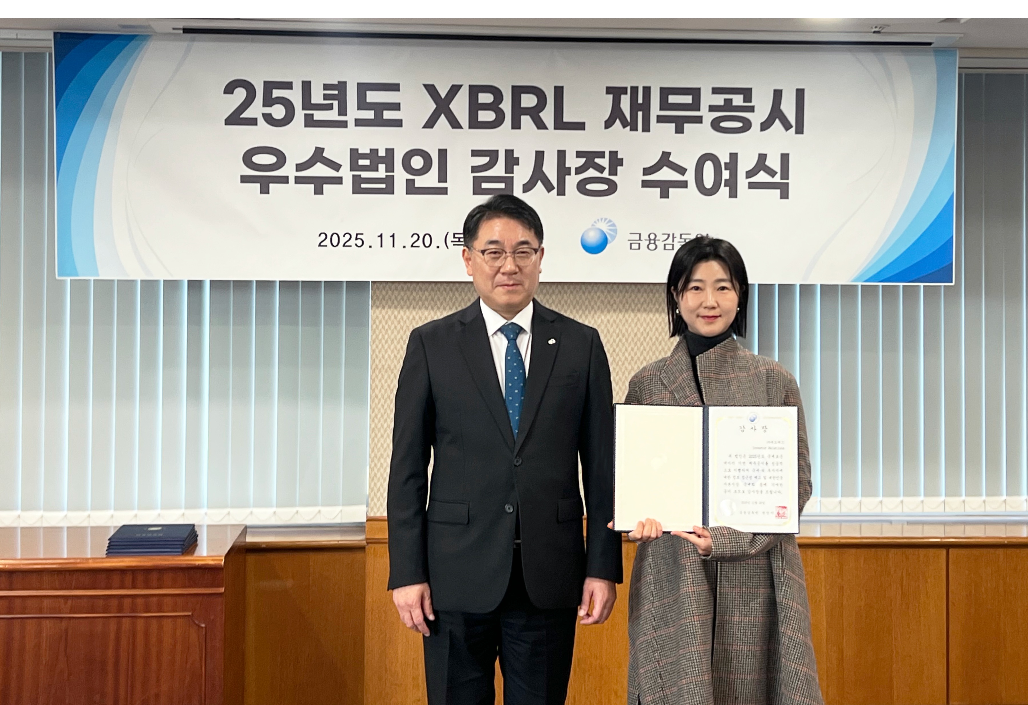 지난 20일 진행된 ‘XBRL 재무공시 우수법인 감사장 수여식’에서 박아람 네오위즈 공시 담당(오른쪽)이 이승우 금융감독원 부원장보와 기념촬영을 하고 있다. 사진=네오위즈