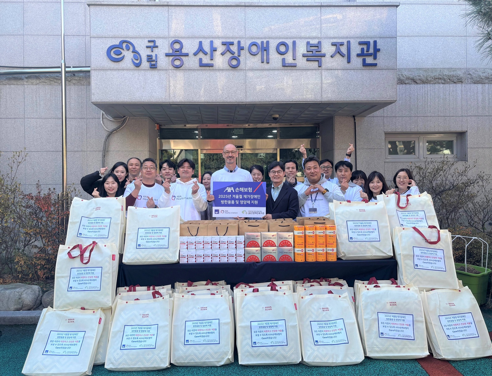 한스 브랑켄 악사손해보험 대표이사(좌)와 권기용 구립용산장애인복지관 관장(우) 및양사 임직원들이 재가장애인 가구를 위한 ‘겨울철 방한용품 및 영양제 패키지’ 전달식 행사를 진행했다. 사진제공=악사손해보험