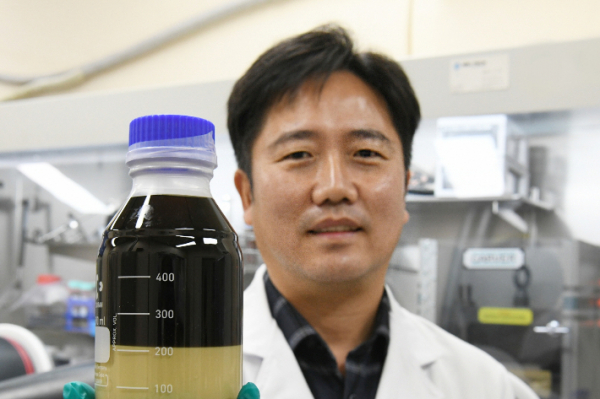 한국 전기 연구원(KERI) 차세대 전지 연구 센터의 하윤철 박사가 공침법을 통해 분리된 고체 전해질과 유기 용매를 들어 보이고 있다. 출처=한국 전기 연구원(KERI)