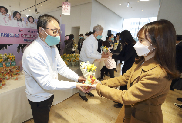 (사진 왼쪽부터)KT 구현모 대표와 최장복 노조위원장이 광화문에 위치한 KT 이스트 사옥에서 여성 임직원에게 꽃을 나눠주고 있다. 출처=KT