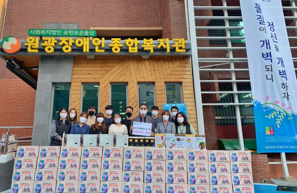 하이트진로는 원광장애인복지관에 희망나눔박스를 전달 하고 김선기(앞줄 오른쪽 3번째) 관장을 포함한 직원들과 기념촬영을 진행했다. 출처=하이트진로