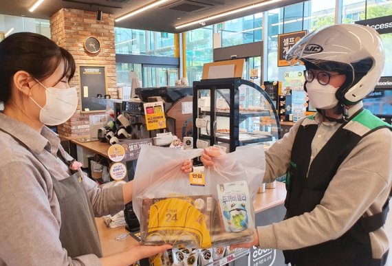 이마트24 점포에서 직원이 배달기사님에게 상품을 전달하고 있다. 출처=이마트24