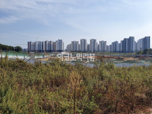 파주운정3지구 '제일풍경채2차 그랑베뉴' 공사 현장 일대. 뒤편으로 대우건설의 '푸르지오 파르세나'를 포함한 아파트 단지가 보인다. ​​​​​​​사진=이코노믹리뷰 이소현 기자