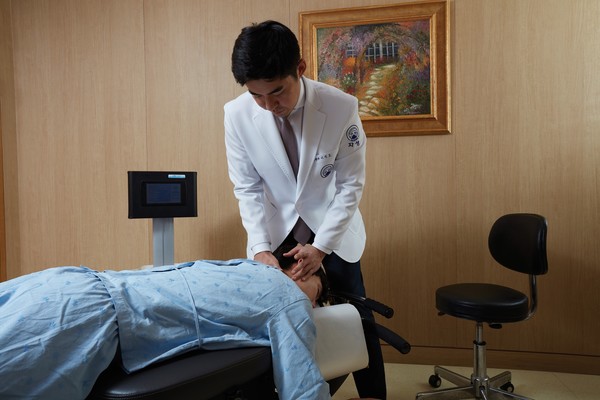 자생한방병원 의료진이 목 통증 환자에게 추나요법을 실시하고 있다 . 출처=자생한방병원