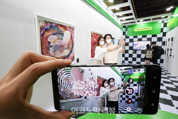 KIAF PLUS(한국국제아트페어)가 열리고 있는 서울 대치동 SETEC에서 2일 관람객이 스마트폰을 이용해 전시작품을 증강현실 아트워크로 감상하고 있다.한성자동차는 올해 키아프 플러스 전시회를 공식 후원하고 있으며 전시장 내 버거샵 컨셉의 전시 공간을 통해 증강현실(AR, Augmented Reality) 기반의 버니 ‘메타버니(Metabun_ny)’ 아트워크를 선보이고 있다. 키아프 플러스 전시회는 올해 처음 신설된 아트페어로 오는 9월 5일(월)까지 진행된다.사진=한성자동차