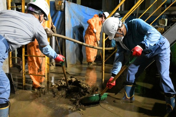 최정우 포스코그룹 회장(오른쪽)이 지난 9월17일 포항제철소 지하설비를 찾아 태풍 피해로 밀려들어온 진흙과 뻘을 직접 퍼내고 있다. 출처=포스코