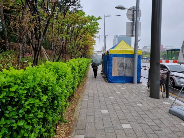 지난 18일 서울 서초구 현대자동차그룹 본사 앞 인도에 설치된 시위자 천막 옆으로 행인이 지나가는 모습. 사진=최동훈 기자