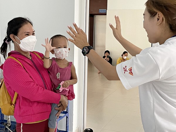 ‘베트남 얼굴기형 어린이 무료수술’ 행사에 참여한 SK 대학생 자원봉사단 ‘SK 써니’ 참가자들이 수술한 어린이들과 가족을 위로하는 봉사 활동을 펼치고 있다. 사진= SK 