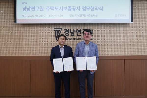 김종서 HUG 주택도시금융연구원장(왼쪽)과 송부용 경남연구원장이 23일 경남연구원 4층 회의실에서 업무협약을 체결한 뒤 기념 촬영하고 있다. HUG 제공