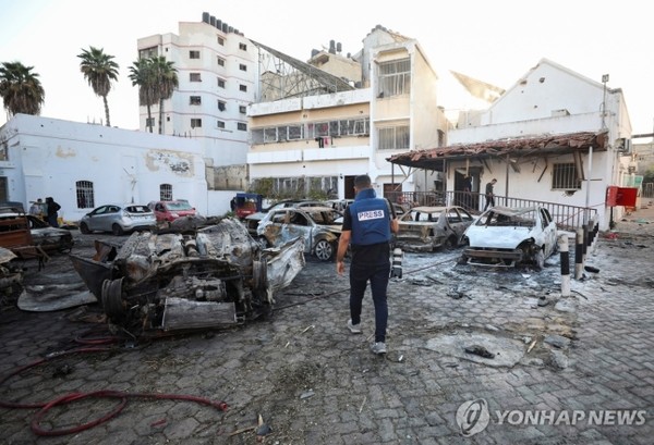 지난 17일(현지시간) 폭발로 불에 탄 팔레스타인 가자지구 북부 가자시의 알아흘리 아랍 병원 주차장으로 기자가 걸어가고 있다. 사진=연합뉴스