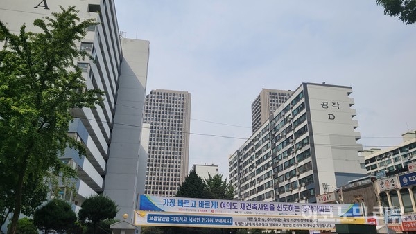 서울 영등포구 여의도동의 한 구축 단지 앞에 재건축 사업에 대한 내용이 담긴 현수막이 걸려 있다. 사진=이혜진 기자