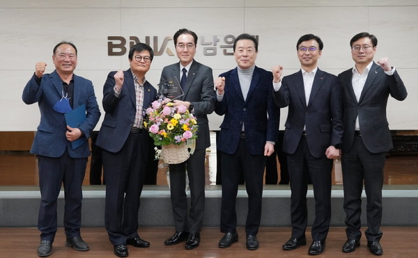 예경탁 BNK경남은행장(왼쪽 세 째)이 27일 BNK경남은행 본점에서 ‘대한육상연맹 공로상’을 받은 뒤 관계자들과 기념촬영을 하고 있다. 사진 = BNK경남은행.