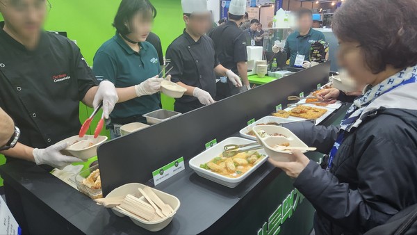 관람객들이 풀무원 부스에서 배식받고 있다. 사진=박상준 이코노믹리뷰 기자