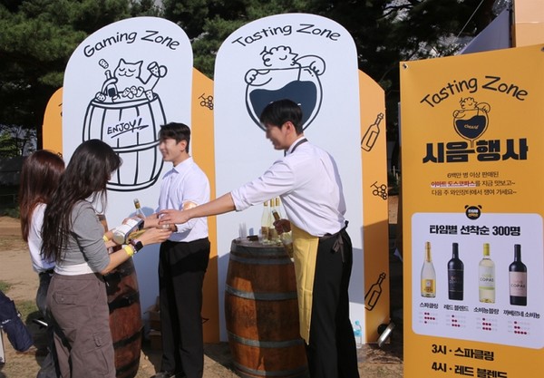 지난 12일 토요일 오후 올림픽공원 88잔디마당에 마련된 이마트 ‘와인장터’ 부스에서 와인을 시음하고 있는 방문객의 모습. 사진=이마트