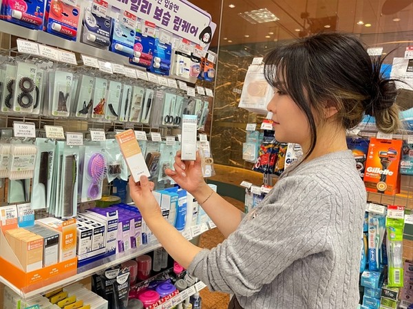 모델이 GS25에서 출시한 3000원 가성비 화장품을 살펴보고 있다. 사진=GS리테일