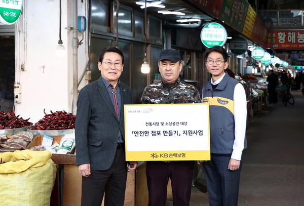 윤희승 KB손해보험 상무(오른쪽), 조진식 의정부제일시장 번영회장(왼쪽)이 18일 경기도 의정부시 의정부제일시장에서 안전점검을 받은 소상공인과 함께 기념사진을 찍고 있다. 사진=KB손해보험