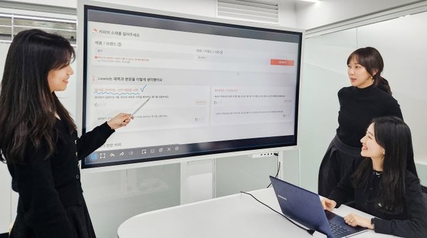 현대백화점 직원들이 스마트TV를 활용해 AI 카피라이터 '루이스'를 시연하고 있는 모습. 사진=현대백화점그룹