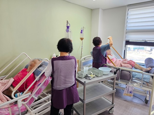 지난 3일 경기 양주시의 가연재활요양원에서 요양보호사들이 와상 환자 어르신에게 경장영양제를 투입하고 있다. 사진=연합뉴스