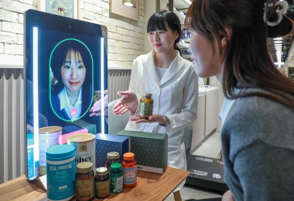 고객이 현대백화점 목동점 네슬레 헬스사이언스 매장에서 AI 기반 헬스케어 전문 기기 ‘아누라 매직미러(Anura Magic Mirror)’를 체험하고 있는 모습. 사진=현대백화점그룹