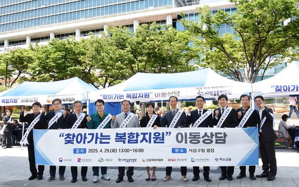 29일 부산 사상구청 앞 광장에서 '찾아가는 복합지원' 이동상담 행사가 열린 가운데 참석자들이 기념촬영을 하고 있다. 출처=신복위