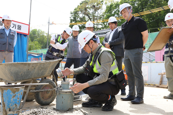 롯데건설 직원이 서초 헌인마을 현장에서 ‘차세대 혼화제’가 적용된 콘크리트를 테스트하고 있다. 사진=롯데건설