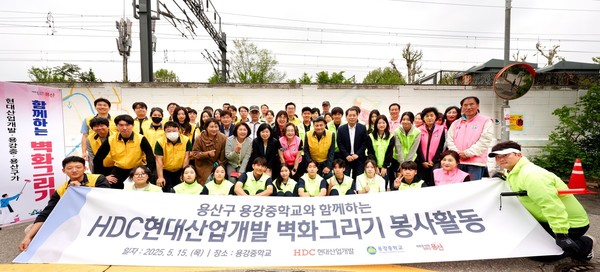 HDC현대산업개발은 15일 도시정비부문 임직원과 용산구 주민, 용강중학교 학생 등 40여 명과 함께 서울시 용산구 용강중학교 일대 담장 벽화그리기 봉사활동을 진행했다. 사진=HDC현대산업개발