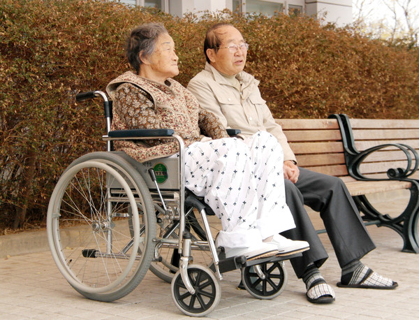 골다공증으로 병원에 입원한 박창순씨가 의료원 내 벤치에서 남편 임채윤씨와 대화를 나누고 있다. 사진=연합뉴스
