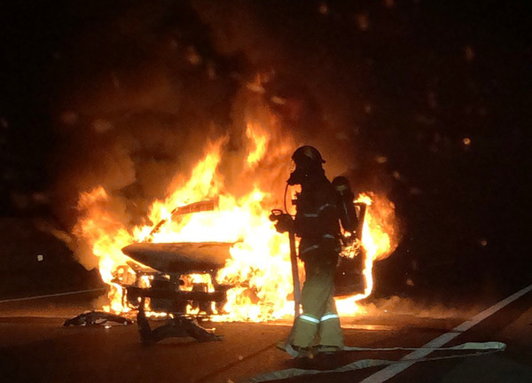 충남 홍성군 서해안고속도로 서울 방면 홍성휴게소 부근을 지나던 그랜저 승용차가 갓길 콘크리트 방호벽을 들이받고 불이나 출동한 소방대원이 교통사고 화재를 진압하고 있다. 사진=연합뉴스