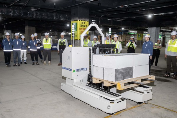 현대건설과 삼성물산이 공동 개발한 ‘스마트 자재 운반 로봇’이 현장에서 자재를 싣고 자율주행 이동하고 있다.