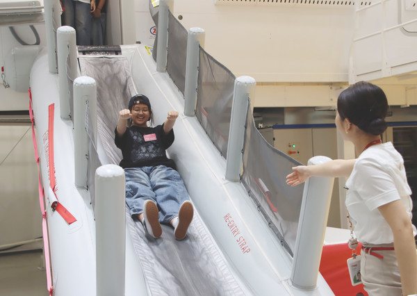 지난 8일 오후 티웨이항공 훈련센터에서 객실 승무원 체험 활동에 참여한 속초양양지역 중학생들이 B737 항공기 슬라이드 훈련을 체험하고 있다. 사진=티웨이항공