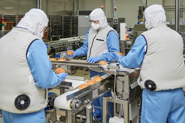 던킨 안양공장 직원들이 온열 질환 예방을 위해 마련된 냉풍조끼를 입고 작업하는 모습. 사진=SPC그룹