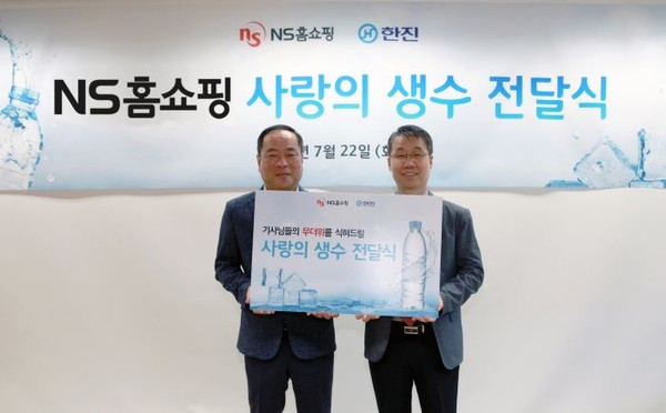 NS홈쇼핑이 택배기사들을 위한 ‘사랑의 생수 전달식’을 22일 진행했다. 왼쪽부터 강영철 한진택배 상무, 유대희 NS홈쇼핑 고객지원본부 본부장. 사진=NS홈쇼핑