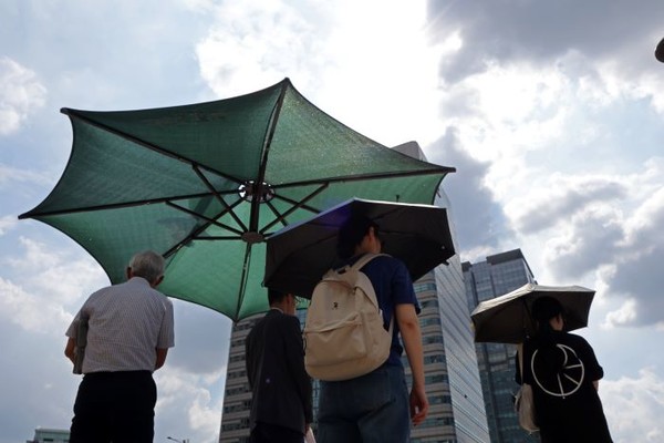 더운 날씨가 이어지는 지난 23일 서울 광화문광장에서 시민들이 뜨거운 햇볕을 맞으며 걸어가고 있다. 사진=연합뉴스