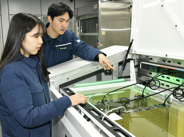 액침냉각설비에 담긴 냉각유와 서버를 테스트하고 있는 HD현대오일뱅크 직원들. 사진=HD현대오일뱅크