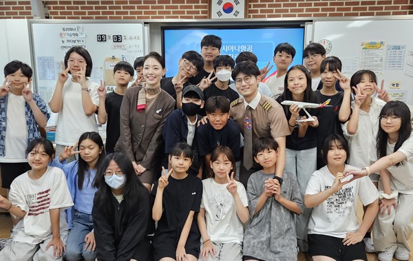 서울공진초등학교에서 열린 항공진로 직업특강에서 (왼쪽부터)이민정 부사무장, 이동준 부기장이 학생들과 기념촬영을 하고 있다. 사진=아시아나항공