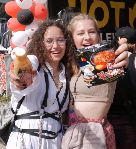 불닭 소스와 불닭볶음면을 들고 서있는 외국인들. 사진=삼양식품