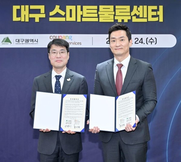 김정기 대구광역시장 권한대행(좌측)과 곽형주 쿠팡로지스틱스서비스 상무가 지난 24일 오후 대구광역시청에서 열린 ‘쿠팡로지스틱스서비스 대구 스마트물류센터 신설 투자협약식’에서 협약서를 들고 사진 촬영을 하고 있다. 사진=쿠팡