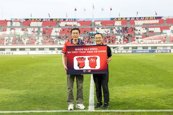 김천시 출생아 100가정을 선정해 특별제작한 유니폼 형식의 유아용 바디수트를 후원했다. 김일배 한전기술 김일배 부사장(왼쪽)과 이재하 김천상무 대표이사. 사진=한국전력기술