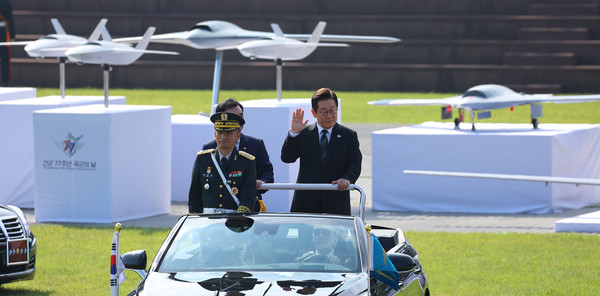 건군 77주년 국군의날 행사에서 사열하는 이재명 대통령 뒤로 유무인 복합체계 관련 무인기 모형이 보인다. 사진=연합뉴스